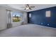 Spacious bedroom with a large window showcasing views and a striking navy accent wall at 19820 E Reins Rd, Queen Creek, AZ 85142