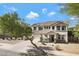 Charming two-story home with manicured landscaping and a welcoming entrance, set against a blue sky at 19820 E Reins Rd, Queen Creek, AZ 85142