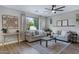 Bright living room with a large window overlooking lush greenery, complemented by comfortable seating and decor at 19820 E Reins Rd, Queen Creek, AZ 85142