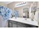 Bathroom featuring double sinks, a large mirror, and a shower with a blue floral curtain at 2049 N 77Th Dr, Phoenix, AZ 85035