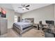 Comfortable bedroom with a ceiling fan, large bed, and a sliding door leading to a balcony at 2049 N 77Th Dr, Phoenix, AZ 85035