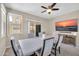 Cozy dining room features a modern table set, a ceiling fan, and a mounted TV at 2049 N 77Th Dr, Phoenix, AZ 85035