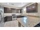 Modern kitchen boasting stainless steel appliances, granite countertops, and dark wooden cabinets at 2049 N 77Th Dr, Phoenix, AZ 85035