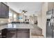 Open-concept living area featuring a kitchen island, ceiling fan, and neutral tones at 2049 N 77Th Dr, Phoenix, AZ 85035