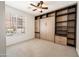 A stylish bedroom featuring a Murphy bed with built-in storage and a large sunny window at 21817 N 39Th St, Phoenix, AZ 85050