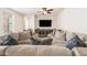 A spacious living room with a large sectional sofa, a ceiling fan, and a media center at 21817 N 39Th St, Phoenix, AZ 85050