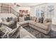 Bright living room features a large sectional sofa, staircase and view of a modern kitchen at 21817 N 39Th St, Phoenix, AZ 85050