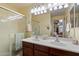 Bathroom with a double sink vanity, glass shower doors, and neutral-toned carpet at 26408 N 53Rd Gln, Phoenix, AZ 85083