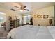 A cozy bedroom with yellow walls, ceiling fan, and neutral-toned carpet at 26408 N 53Rd Gln, Phoenix, AZ 85083