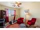 This bedroom includes a ceiling fan, two red chairs, treadmill, and decor at 26408 N 53Rd Gln, Phoenix, AZ 85083
