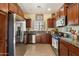 Well-lit kitchen featuring stainless steel appliances, granite countertops, and dark wood cabinetry at 26408 N 53Rd Gln, Phoenix, AZ 85083