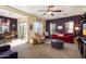 Open living room with a ceiling fan, large windows and comfortable seating and a red sofa at 26408 N 53Rd Gln, Phoenix, AZ 85083