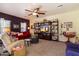 Spacious living room featuring a ceiling fan, comfortable seating, and display shelves at 26408 N 53Rd Gln, Phoenix, AZ 85083