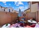 This patio is surrounded by tan fences and includes an umbrella, chairs, and decor at 26408 N 53Rd Gln, Phoenix, AZ 85083