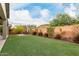 Spacious backyard featuring well-maintained artificial turf, a patio set, and desert landscaping at 27289 N 90Th Ave, Peoria, AZ 85383