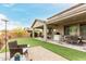 Expansive backyard with artificial grass, covered patio, and various seating areas for outdoor relaxation at 27289 N 90Th Ave, Peoria, AZ 85383