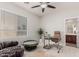 Carpeted bedroom with ceiling fan, desk, chair, and view into bathroom at 27289 N 90Th Ave, Peoria, AZ 85383