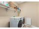 Well-equipped laundry room featuring modern, front-loading washer and dryer and built in shelving at 27289 N 90Th Ave, Peoria, AZ 85383