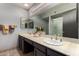 Bathroom showcasing double sinks with marble countertops, a large mirror, and a glass shower at 3106 S Extension Rd, Mesa, AZ 85210
