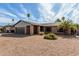 A desert-landscaped single-Gathering home featuring a brick facade, a metal awning, and a large palm tree in the front yard at 3106 S Extension Rd, Mesa, AZ 85210