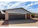 Garage of a single-Gathering home with a gray metal awning and a concrete driveway, surrounded by desert landscaping at 3106 S Extension Rd, Mesa, AZ 85210