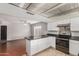 An eat-in kitchen featuring hardwood floors, white cabinetry, black countertops, and stainless steel appliances at 3106 S Extension Rd, Mesa, AZ 85210