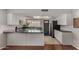 Eat-in kitchen featuring white cabinets, black countertops, tile floors, stainless steel appliances, and ample storage at 3106 S Extension Rd, Mesa, AZ 85210