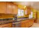 Well-equipped kitchen featuring wooden cabinets, granite countertops, and stainless steel appliances at 323 E Griswold Rd, Phoenix, AZ 85020