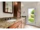 Bathroom features a double sink vanity with granite countertops and a door to the backyard at 3255 E Malapai Dr, Phoenix, AZ 85028