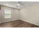 A well-lit bedroom with modern ceiling fan, window, and hardwood floors at 3255 E Malapai Dr, Phoenix, AZ 85028