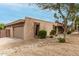 Side view of a home with a tan exterior, desert landscaping and an attached garage at 3255 E Malapai Dr, Phoenix, AZ 85028