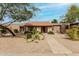 Charming single-story home with desert landscaping, pathway and red front door at 3255 E Malapai Dr, Phoenix, AZ 85028