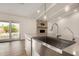 Kitchen island with a stainless steel sink, stone accent wall, and access to the pool at 3255 E Malapai Dr, Phoenix, AZ 85028