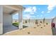 A backyard with a covered patio, stone pavers, rock landscaping, and a perimeter wall at 38115 W Excussare Way, Maricopa, AZ 85138