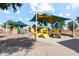 Community playground featuring climbing structures, slides, and shade canopies at 38115 W Excussare Way, Maricopa, AZ 85138