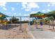 Community playground with slides and swings offering a fun and shaded play area for residents at 38115 W Excussare Way, Maricopa, AZ 85138