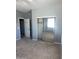 Bright bedroom featuring sliding closet doors and neutral colored walls and carpet at 4151 E Campbell Ave, Gilbert, AZ 85234