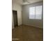 Bright bedroom featuring neutral walls, tile flooring, and a large window for optimal sunlight at 4151 E Campbell Ave, Gilbert, AZ 85234