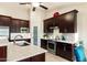 Modern kitchen featuring stainless steel appliances, dark wood cabinets, and light granite countertops at 4611 E Red Bird Rd, Cave Creek, AZ 85331