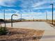 Community basketball court with multiple hoops, lights and mountain views on a sunny day at 46922 W Coe St, Maricopa, AZ 85139