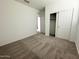 Bedroom featuring plush carpet, bright white walls, and sliding closet doors at 46922 W Coe St, Maricopa, AZ 85139