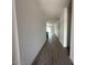 Long hallway with attractive wood flooring that flows into a spacious living area at 46922 W Coe St, Maricopa, AZ 85139