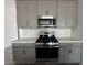 Modern kitchen features stainless steel appliances, light gray cabinets, and light subway tile backsplash at 46922 W Coe St, Maricopa, AZ 85139