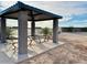 Covered picnic area featuring stone pillars, picnic tables, seating and desert landscaping at 46922 W Coe St, Maricopa, AZ 85139