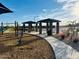 Community picnic area features covered seating, paved pathways, and desert landscaping with young trees at 46922 W Coe St, Maricopa, AZ 85139
