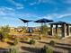 Community playground with play equipment, covered seating, sidewalks, and landscaping at 46922 W Coe St, Maricopa, AZ 85139