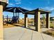Community playground with play equipment, covered seating, sidewalks, and landscaping at 46922 W Coe St, Maricopa, AZ 85139