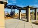 Community playground with play equipment, covered seating, sidewalks, and landscaping at 46922 W Coe St, Maricopa, AZ 85139