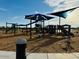 Community playground with various play structures, slides, and equipment on a mulch ground cover at 46922 W Coe St, Maricopa, AZ 85139