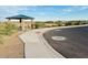 Scenic community area featuring a paved pathway, a covered picnic area, and desert landscaping at 46922 W Coe St, Maricopa, AZ 85139